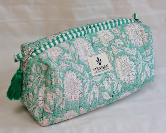 Floral patterned hand block printed pouch with green accents and tassel on a light background