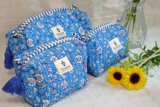 Blue floral-patterned Hand Block Printed bags with tassels on a light surface.
